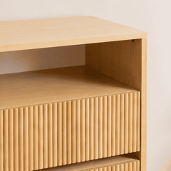 Cómoda de madera «Pitao» con 3 cajones, listones verticales y estante abierto; acabado natural para dormitorio.